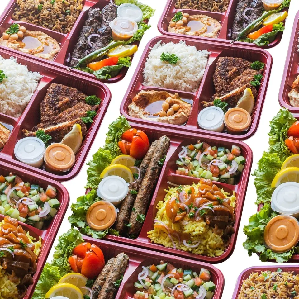 Sababa platters in red trays from above: rice, kebabs, schnitzel, salad and sauces